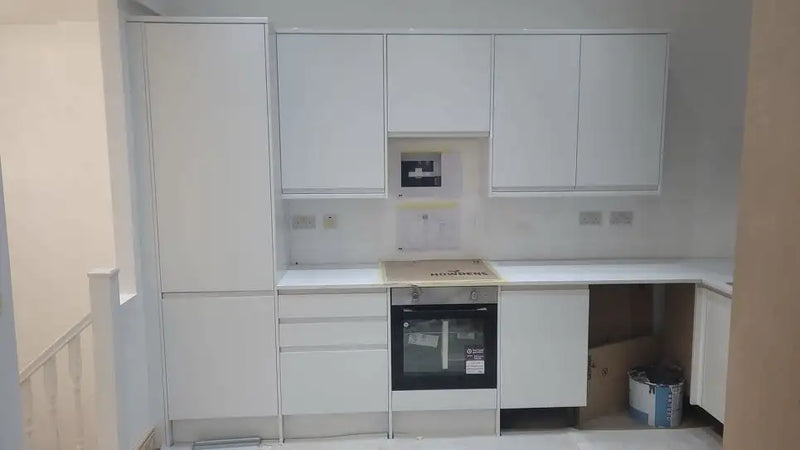 New Howdens handleless kitchen being fitted with integrated oven and white units in London by ODS Plumbing & Construction