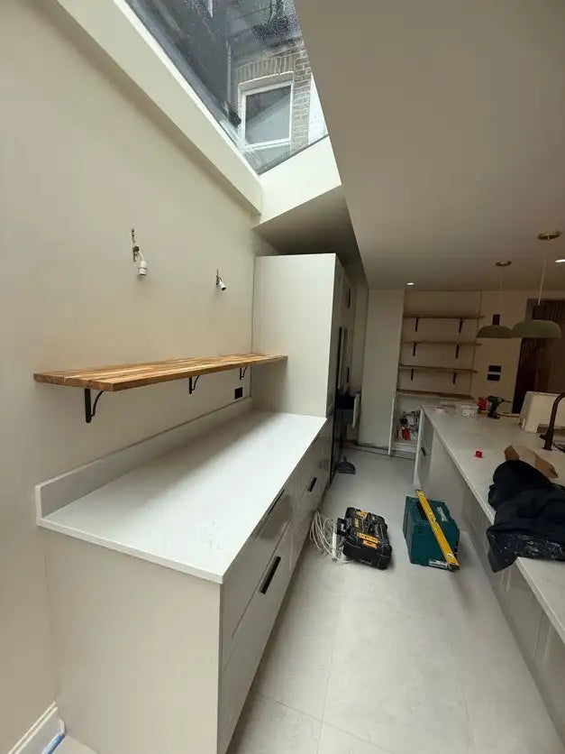 Kitchen extension with rooflight, quartz worktop, solid oak floating shelf and handleless units in London by ODS Plumbing & Construction
