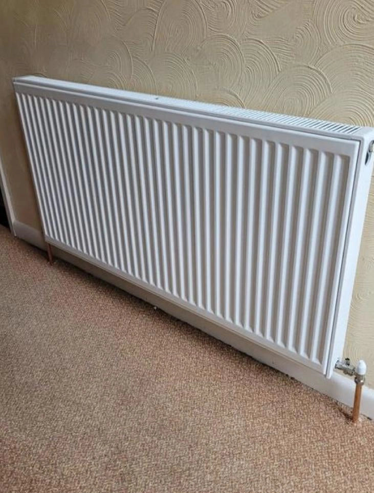 Standard white double panel convector radiator with clean copper pipework and manual valves installed by ODS Plumbing & Construction.