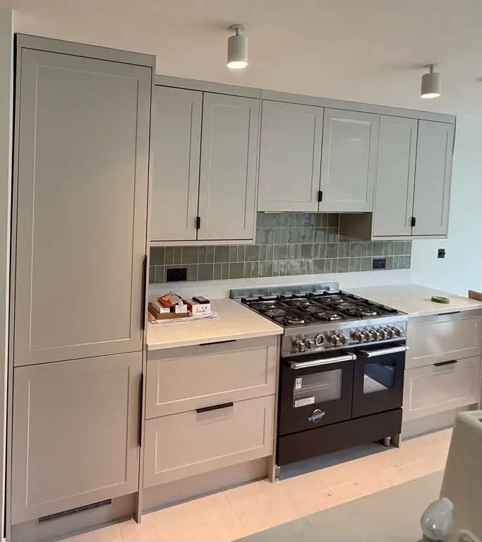 Sage green shaker kitchen with Bertazzoni range cooker, quartz worktop and green metro tile splashback in London by ODS Plumbing & Construction