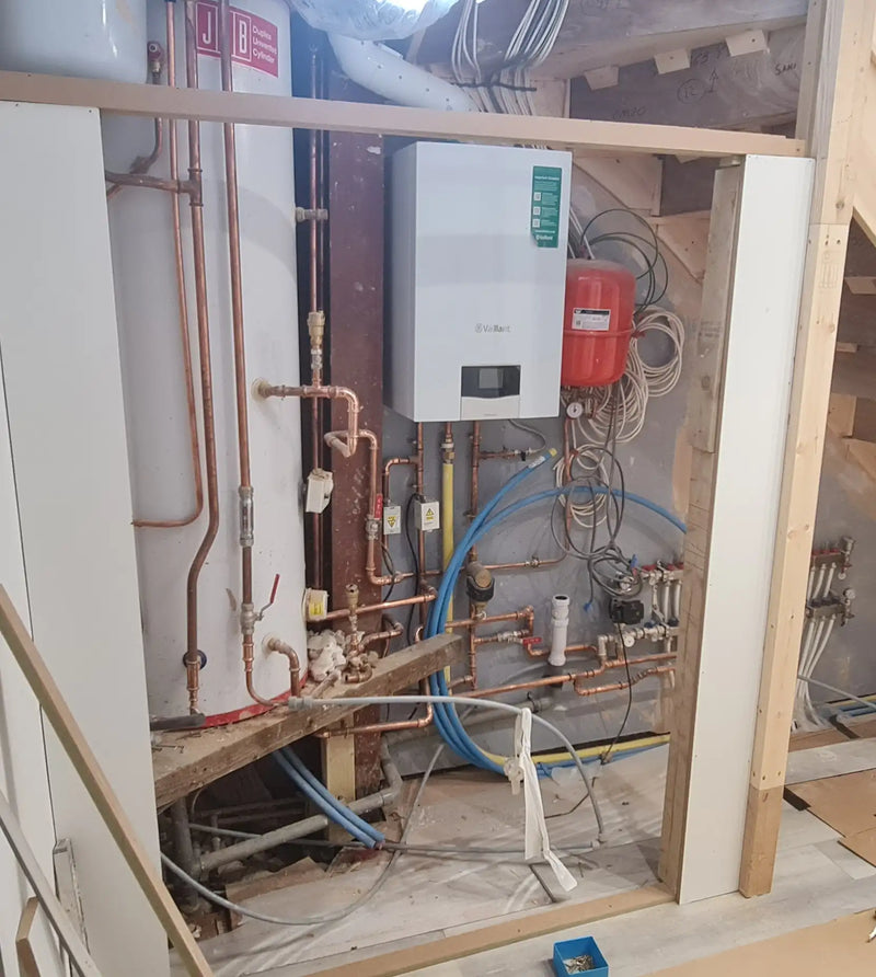 Technical plant room installation featuring a Vaillant boiler, large unvented hot water cylinder, and underfloor heating manifolds by ODS Plumbing & Construction.